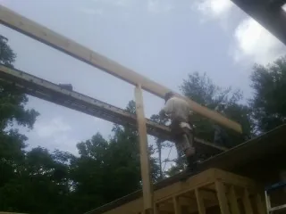 Carpenter setting a ridge beam over a new addition frame — Ice Dam Removal by Roofing Brothers in Ash