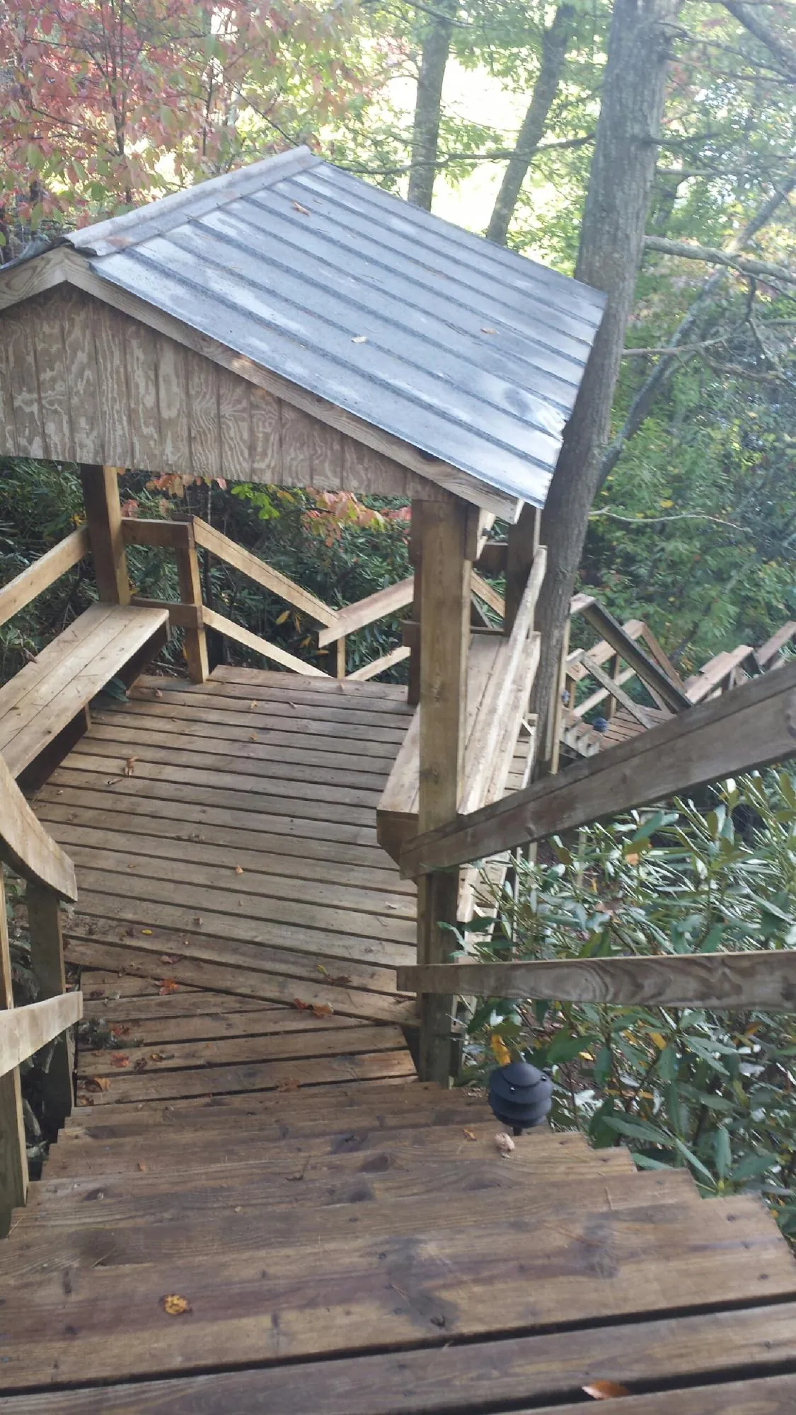 Metal roofed shelter over wooden steps on a wooded walkway — Skylight Repair & Installation work by our crew in Ash