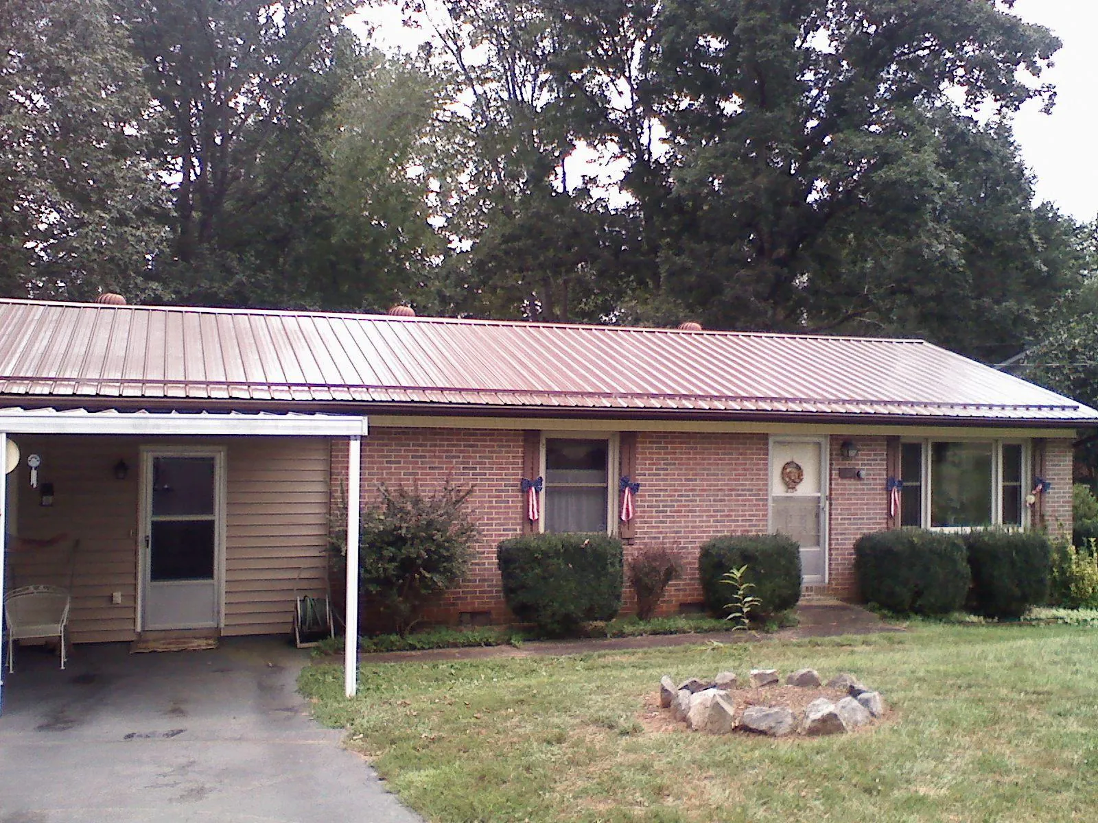 Bronze metal roof and carport on a brick ranch home — Roof Repair work by our crew in Ash