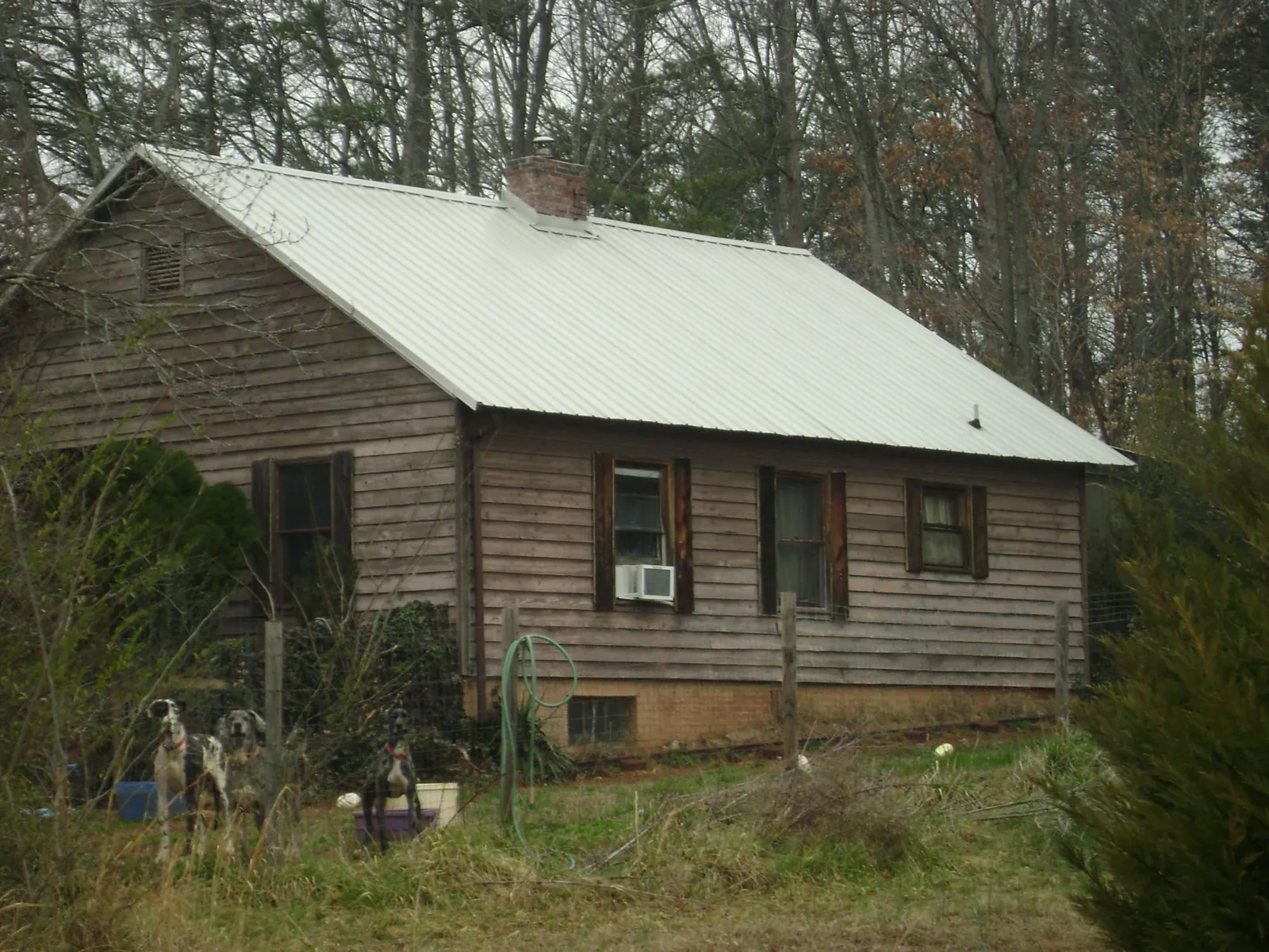 White metal roof on an old wood sided farmhouse, from a Metal Roof Installation job in Ash